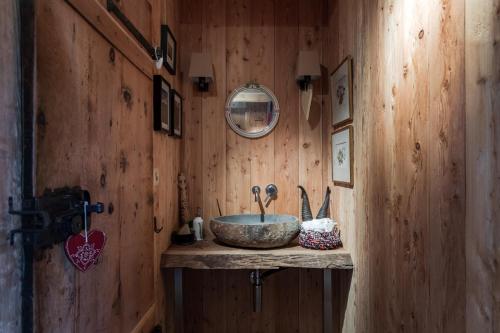 a bathroom with a stone sink on a wooden wall at Chalet La Tsoum in Riddes