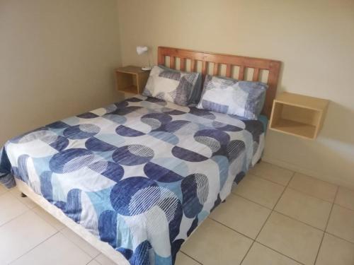 a bedroom with a bed with a blue and white comforter at Portofino Unit 22 in Margate