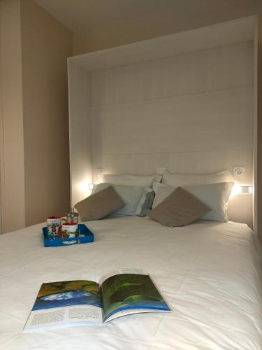 - un livre au-dessus d'un lit blanc dans l'établissement VVF Super-Besse Auvergne Sancy, à Super-Besse