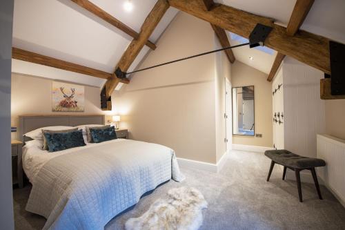 a bedroom with a white bed and a chair at Beckside in West Burton