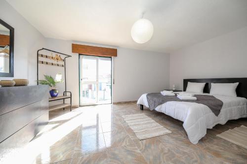 ein Schlafzimmer mit einem großen Bett und einem großen Spiegel in der Unterkunft Moradia Marques in Nazaré