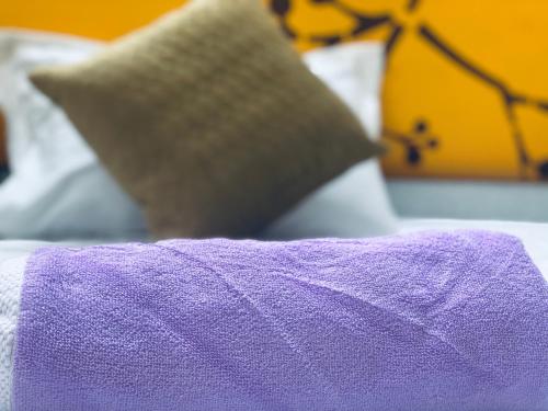a purple blanket on top of a bed with pillows at Jawai Bagpackers Hostel in Sheoganj