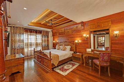 una grande camera da letto con letto, scrivania e di JC Residency Madurai a Madurai