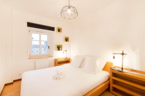 a bedroom with a white bed with a stuffed animal on it at L'atelier de Nicolas - Bel appt au cœur de Nancy in Nancy