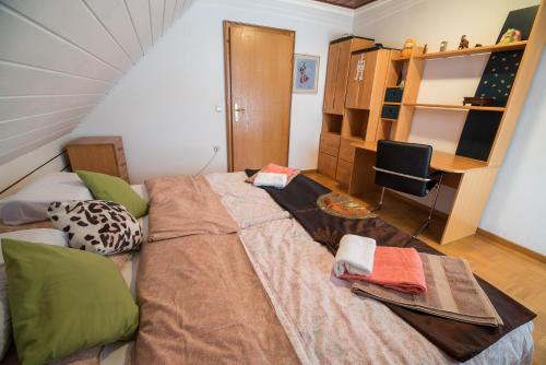 a large bed in a room with a desk at Apartment Tina with Seasonal Pool in Podsreda