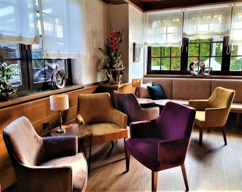 a waiting room with chairs and tables and windows at Dreispitz -B&B-Hotel Garni in Hofheim am Taunus
