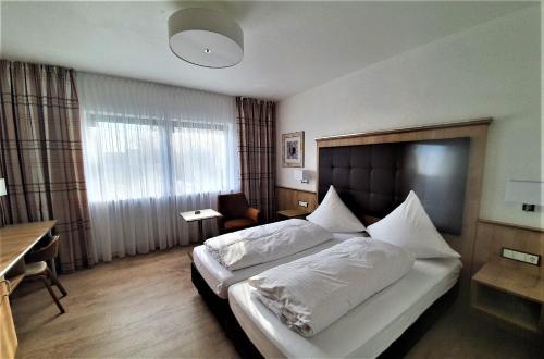 a bedroom with a large bed with white pillows at Dreispitz -B&B-Hotel Garni in Hofheim am Taunus