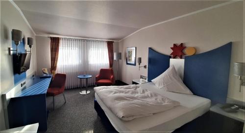 a hotel room with a bed and a table and chairs at Dreispitz -B&B-Hotel Garni in Hofheim am Taunus