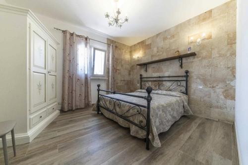 Villa Salux by HDSalento في Taurisano: غرفة نوم بسرير وجدار حجري