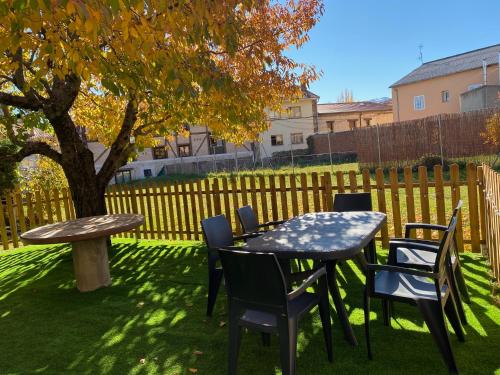 a table and chairs in a yard with a tree at EL CHALET in Rascafría