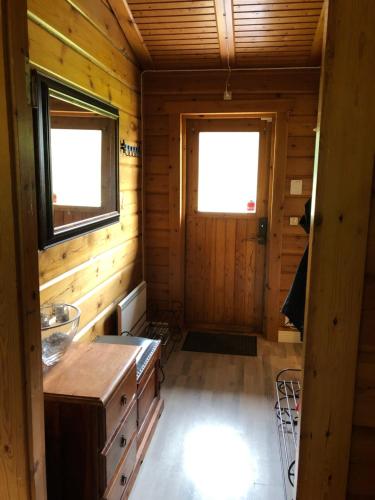 トーシュビューにあるMysig timmerstuga med braskamin nära Hovfjälletの木造キャビン付きの客室で、窓が2つあります。