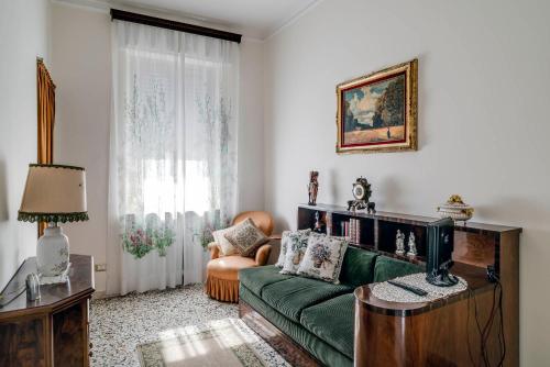 ein Wohnzimmer mit einer grünen Couch und einem Stuhl in der Unterkunft Sentirsi a casa, lontano da casa-feel at home away from home in Caronno Pertusella