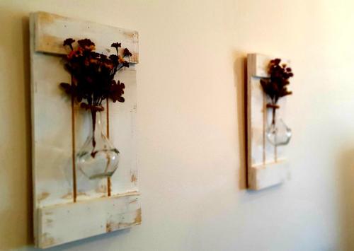 two vases with flowers in them hanging on a wall at EL CHALET in Rascafría