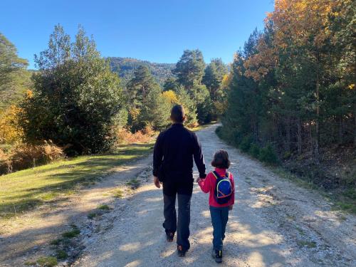 a man and a little girl walking down a dirt road at EL CHALET in Rascafría