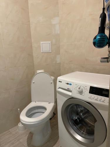 a bathroom with a toilet and a washing machine at 050 Уютные апартаменты ЖК «Софиевская Слободка» in Vyshneve