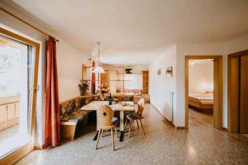 un soggiorno con tavolo e sedie e una camera da letto di Peintnerhof Appartments & Zimmer a Naz-Sciaves