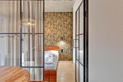 a bedroom with a bed and a table in a room at Grand Apartments - Browar Gdański - Design Apartment in Gdańsk
