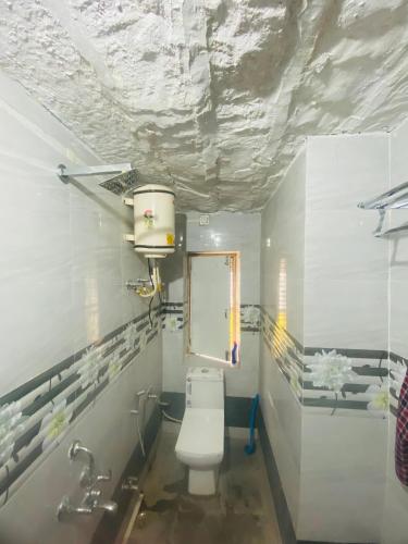 a bathroom with a toilet and a window at Jawai Bagpackers Hostel in Sheoganj