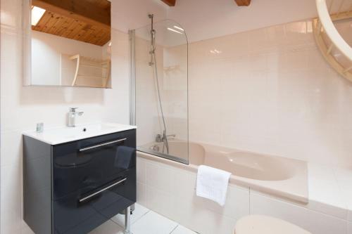 a bathroom with a sink and a bath tub at Maison Trémiere in La Flotte