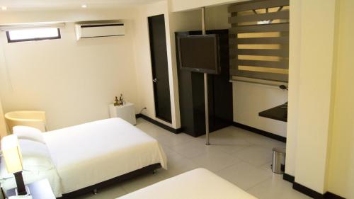 a hospital room with a bed and a tv at Aw Hotel Puerta de San Antonio in Cali