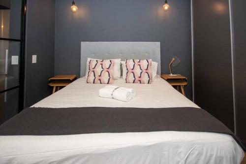 sypialnia z dużym łóżkiem z różowymi poduszkami w obiekcie 514 Wex1 Modern Studio Apartment w Kapsztadzie