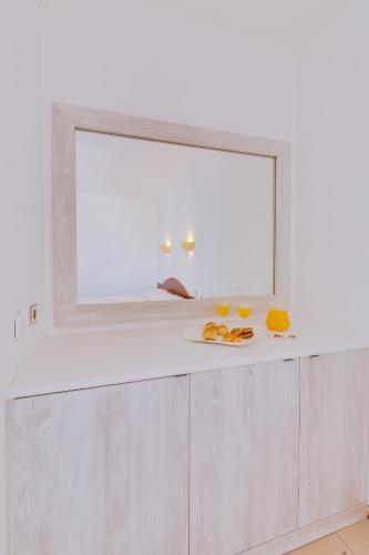 a mirror on a counter with a plate of food at Vila Recife Hotel in Albufeira