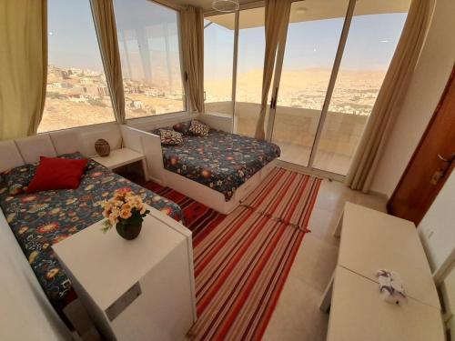 um quarto com um sofá, uma cama e uma janela em Jordan Guest House em Wadi Musa