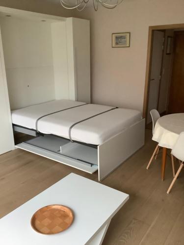 a small room with a bed and a table at Zongerichte studio Sint-Idesbald met mooi zeezicht in Koksijde