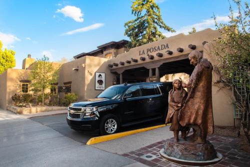 Una estatua de un hombre y una mujer delante de una furgoneta. en La Posada De Santa Fe, a Tribute Portfolio Resort & Spa, en Santa Fe