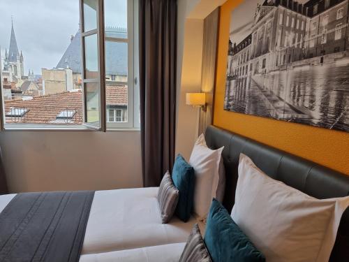a hotel room with a bed and a window at City Loft Apparthotel in Dijon