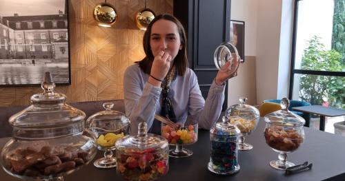 a woman sitting at a table looking in a mirror at City Loft Apparthotel in Dijon