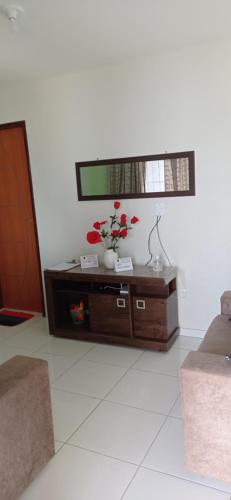 a living room with a table with flowers on it at Flats Xingó in Piranhas