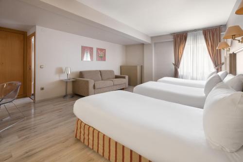 a hotel room with two beds and a couch at Crisol Almirante Bonifaz in Burgos