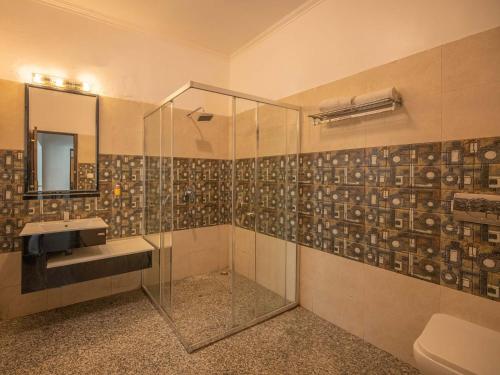 a bathroom with a glass shower and a sink at StayVista at Albert Estate in Mussoorie