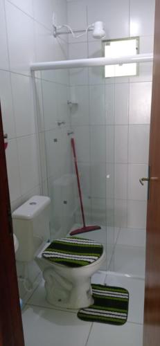 a bathroom with a toilet with a glass wall at Flats Xingó in Piranhas