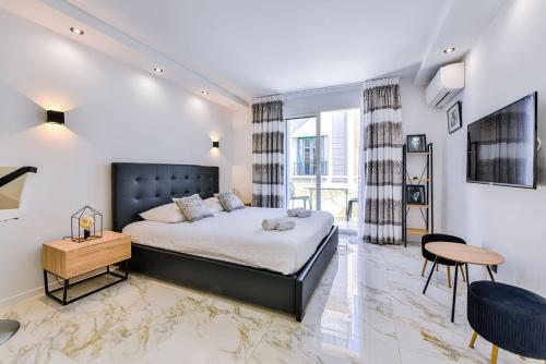 - une chambre avec un lit king-size et une table dans l'établissement Large studio - 50m Cannes beach - terrace sea view, à Cannes