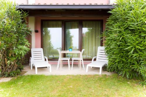 a table and four chairs on a patio with windows at Hotel Belvedere in Manerba del Garda