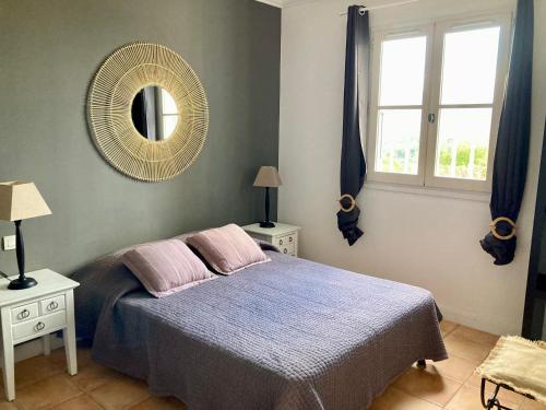 une chambre avec un lit et un miroir au mur dans l'établissement Les Restanques pressoir 3029, à Grimaud