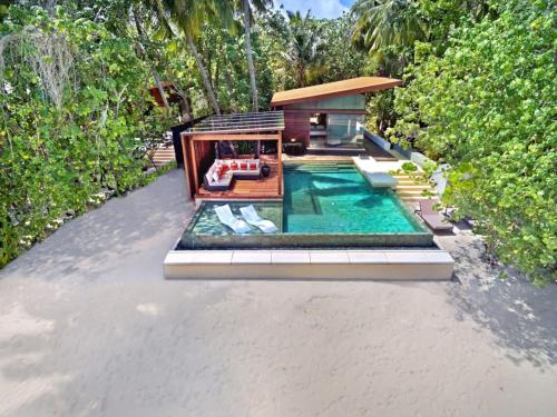 a house with a swimming pool in the middle at Park Hyatt Maldives Hadahaa in Gaafu Alifu Atoll