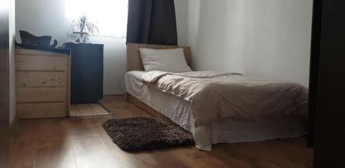 a bedroom with a bed and a dresser and a window at Vila Curtea de Arges in Curtea de Argeş