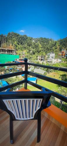 a bench on a balcony with a view of the water at The Maple Inn in Pokhara
