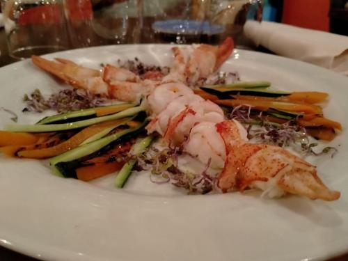 a white plate of food with shrimp and vegetables at La Melosa Resort & Spa in Roccastrada