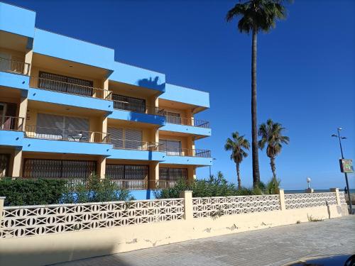a building on the beach with a palm tree at Apartamento Laurel in Peñíscola