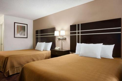 a hotel room with two beds and a telephone at Travelodge by Wyndham Killeen/Fort Hood in Killeen