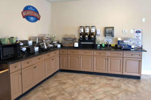 a kitchen with wooden cabinets and a sign on the wall at Baymont by Wyndham Latham Albany Airport in Latham