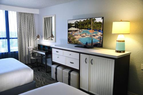 a hotel room with a bed and a desk with a television at Wyndham Lake Buena Vista – Disney Springs® Area in Orlando