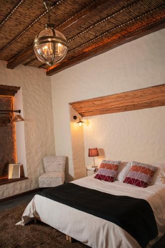 a bedroom with a large bed and a chair at On Hotel Boutique in Sucre