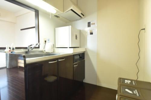 a kitchen with a sink and a microwave at Enzo Shin-Osaka C in Osaka