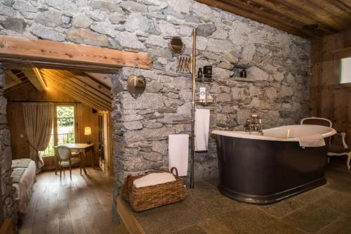 a bathroom with a bath tub in a stone wall at Paccard Locations Chamonix in Chamonix-Mont-Blanc