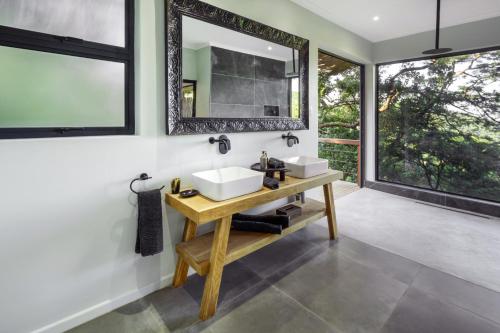 La salle de bains est pourvue de 2 lavabos et d'un miroir. dans l'établissement Sungulwane Private Game Lodge, à Hluhluwe